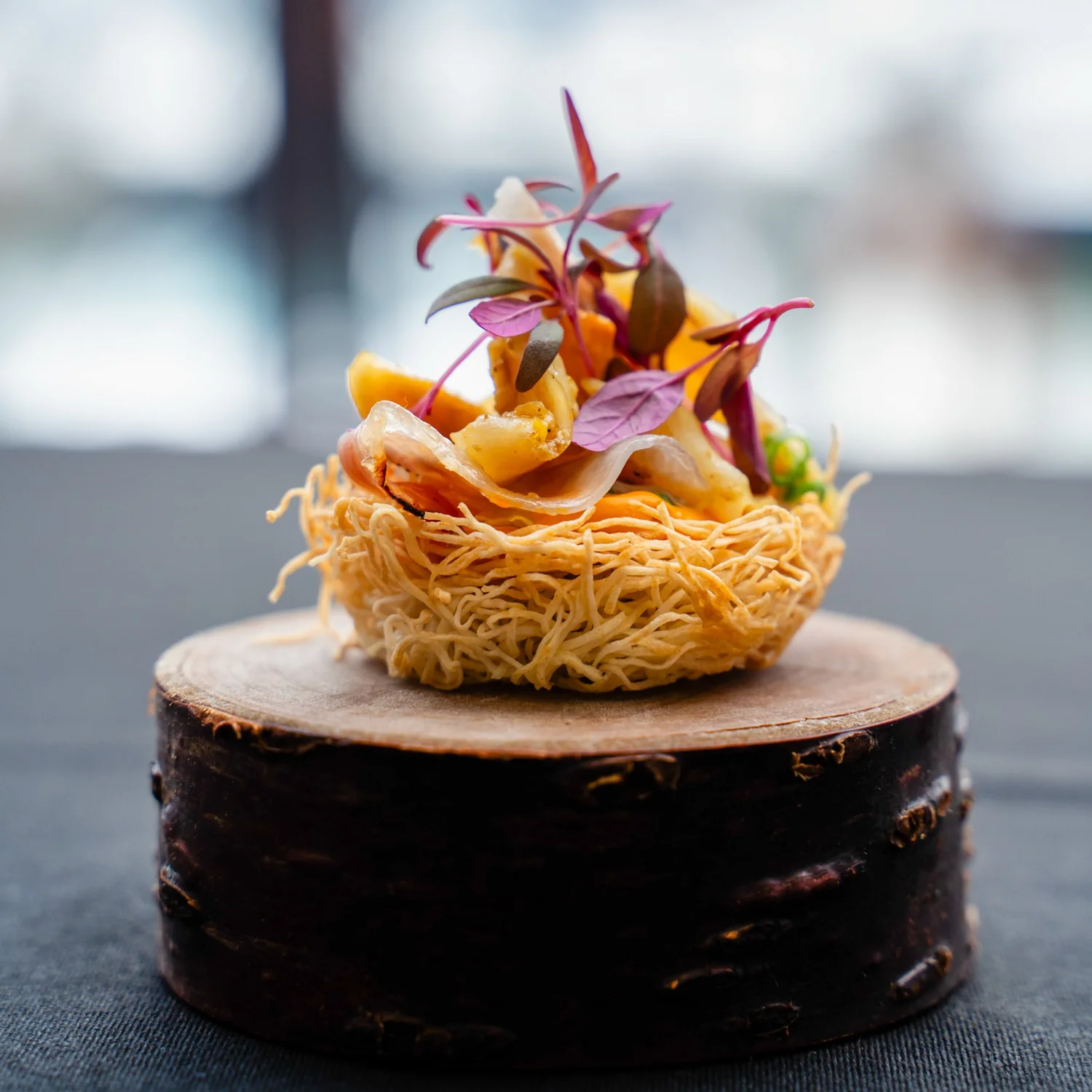 A pistachio dish plated in bowls on warm wood